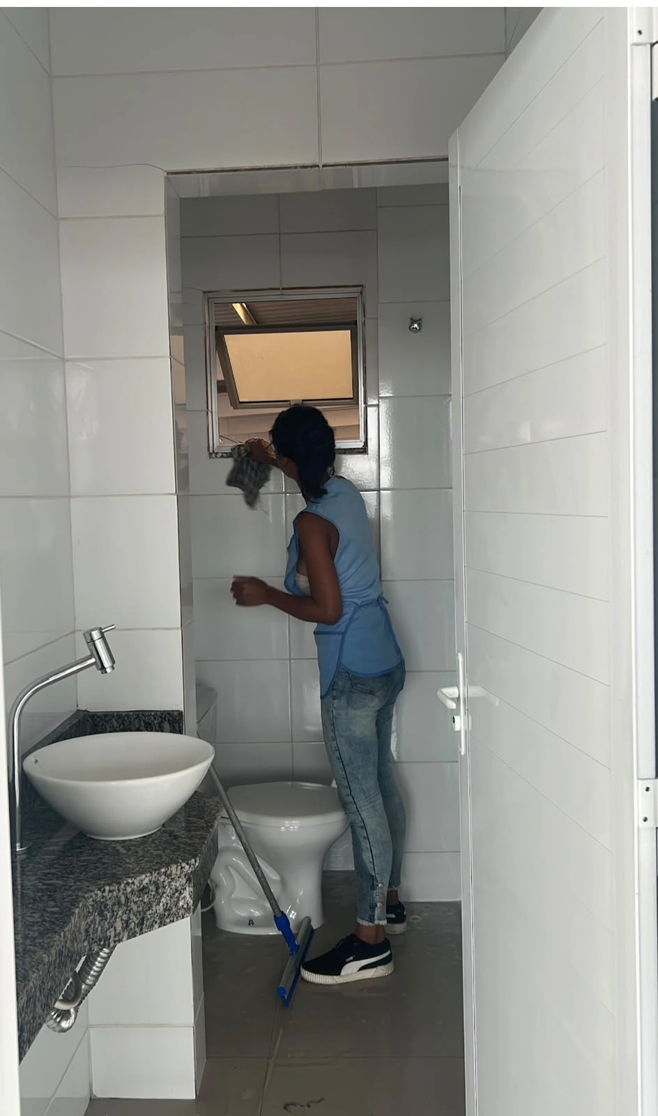 Profissional da equipe limpando acabamentos de um ambiente