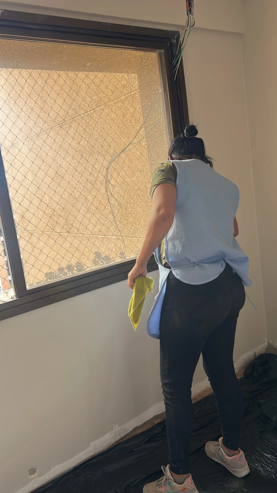 Profissional da equipe realizando limpeza de vidro